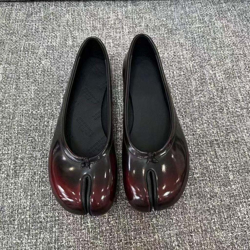 gold and black vegan leather tabi shoes with split toe design on white background