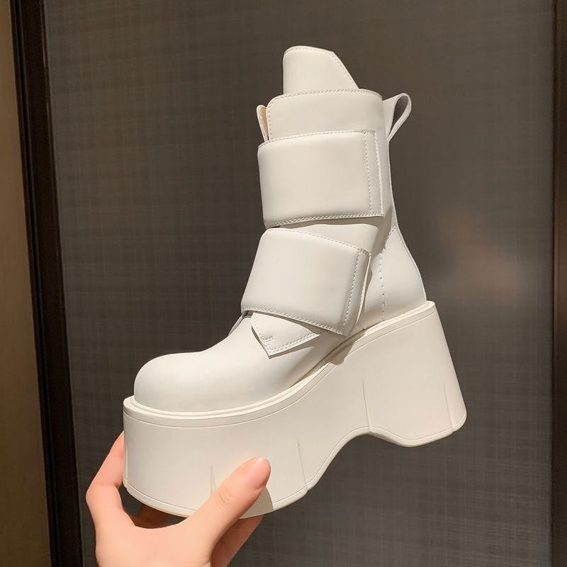 Black mid-calf platform boots with rounded toe and velcro closure paired with wide-leg pants
