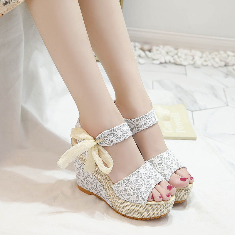 Gorgeous pair of espadrilles with cross-strap, floral print, and wedge heel on sunlit tile floor