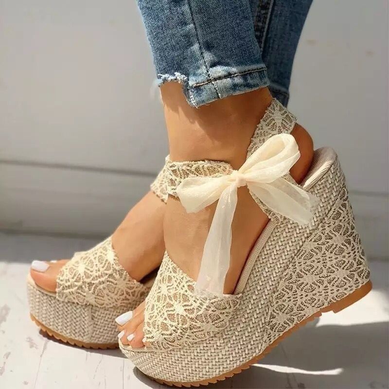 Gorgeous pair of espadrilles with cross-strap, padded footbed, and floral ribbon details on sunlit tiles