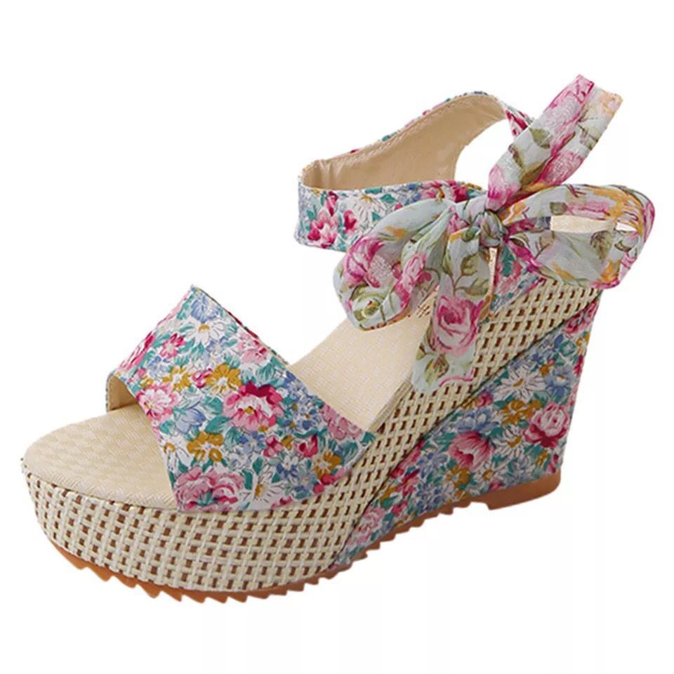 Gorgeous pair of espadrilles with padded footbed, cross-strap, and floral satin ribbons on sunlit tile floor