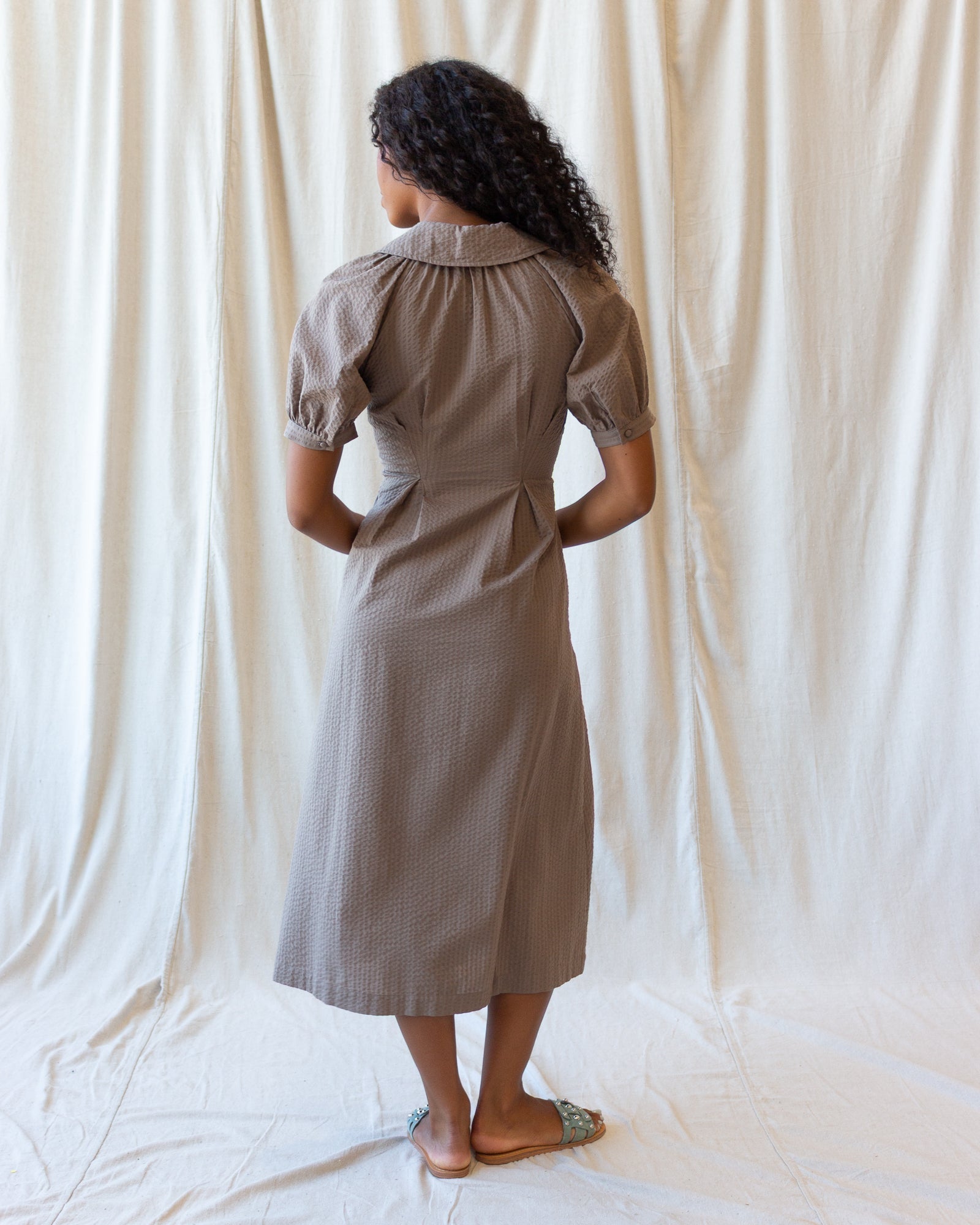 Femme Field Dress in pine bark brown with A-line midi silhouette, button-closure peasant sleeves, and side seam pockets for autumn layering