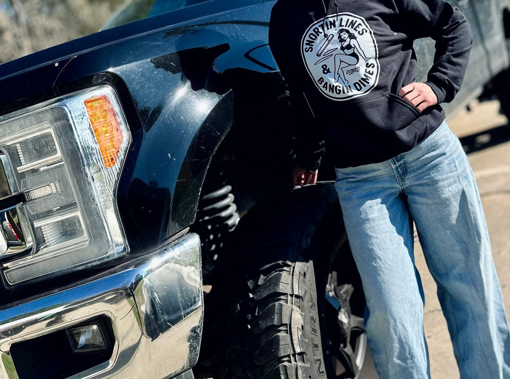 Men wearing black Lines and Dimes Hoodie with vintage pin-up graphic and Luckless Outfitters branding on sleeve