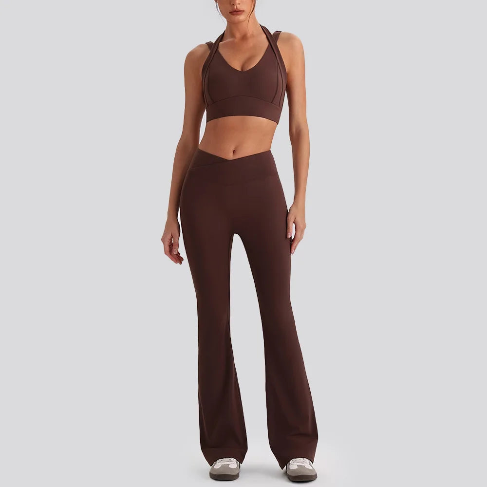 Women wearing backless sports tank top and high waist wide leg pants yoga exercise set in gym