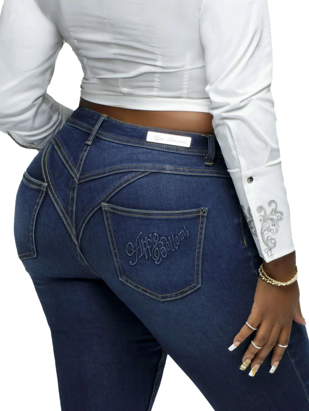Close-up of Apple Bottoms brand thong denim jeans showing stitched posterior detail and tapered ankle-length fit