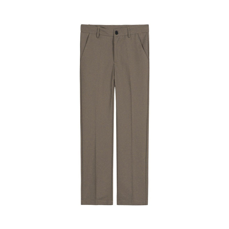 Tall male model wearing slim-fitting low-rise cotton suit pants with belt buckle