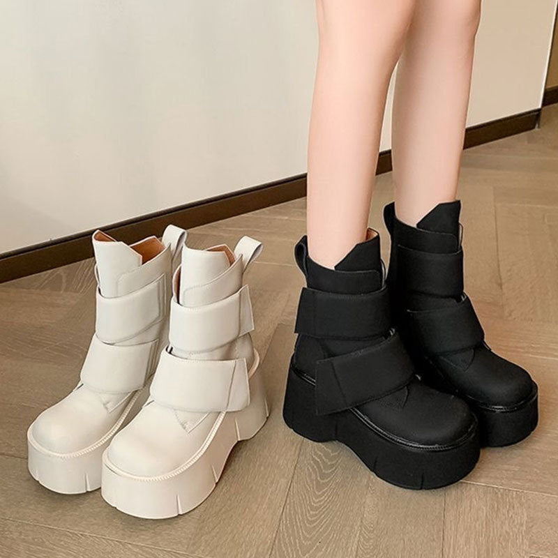 Black mid-calf platform boots with rounded toe and velcro closure styled with wide-leg pants