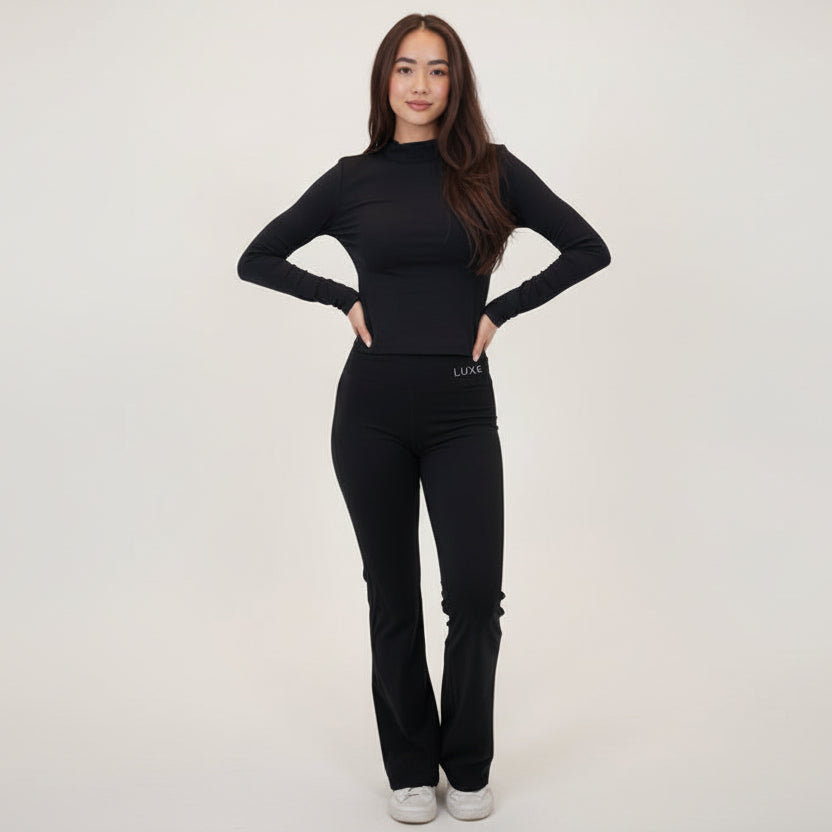 I Live in Luxury Flare Pant in black with high-rise waist and soft flare hem on lightweight quick-dry fabric worn by model